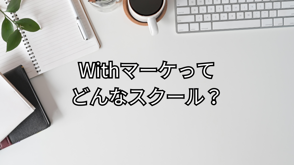 白い机の上にノート、パソコン、コーヒーなどが置いてある